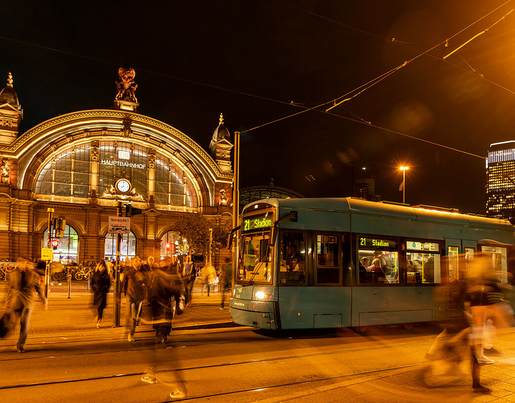 Nachtansicht des Bahnhofsportals in Frankfurt mit Straßenbahn im Vordergrund