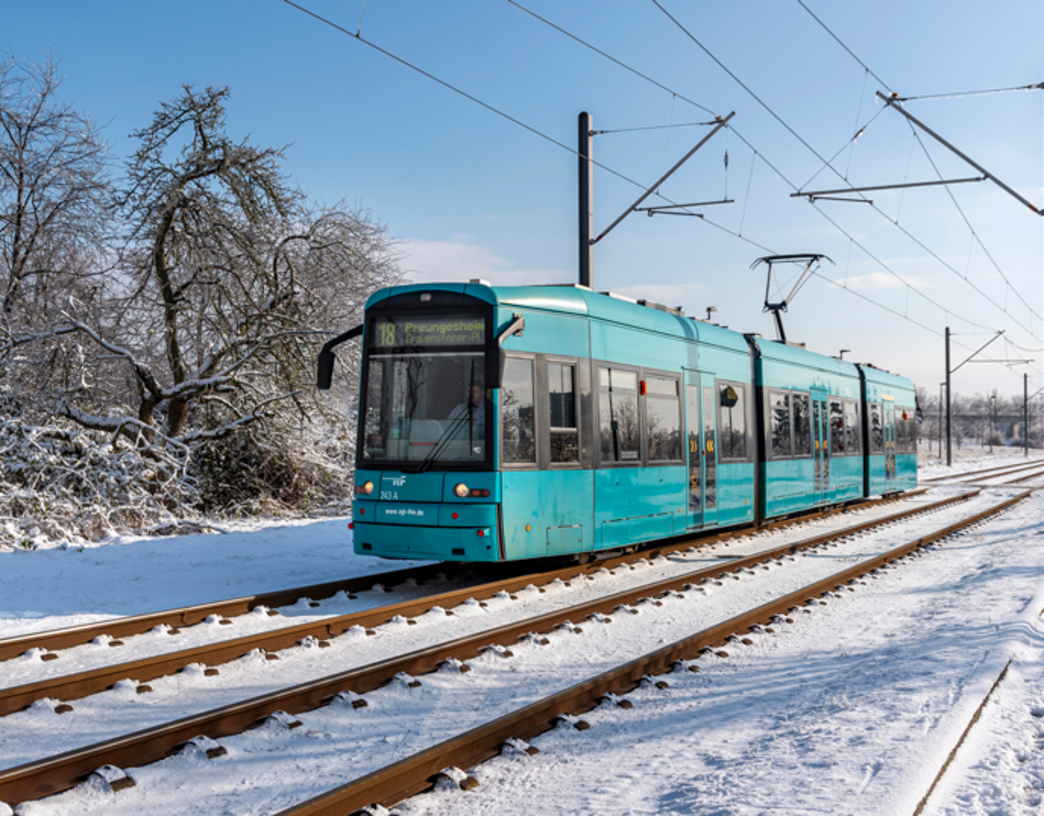 (c) traffiQ; Foto: Helmut Vogler Eine Straßenbahn fährt durch eine verschneite Landschaft in Frankfurt